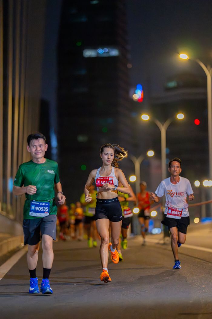 Runners participate in a vibrant urban marathon at night.